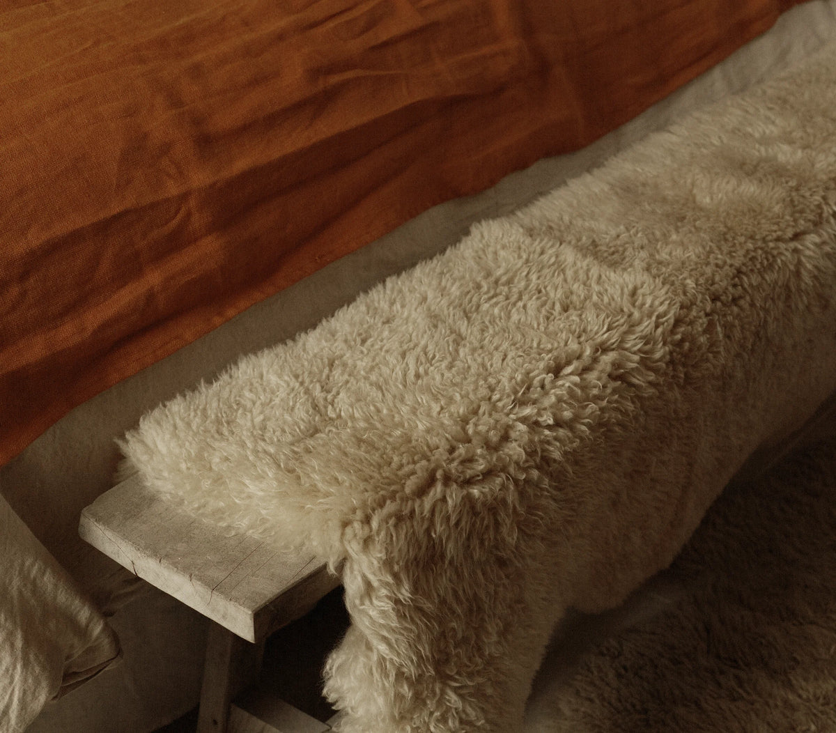 Sheepskin throw over wooden bench