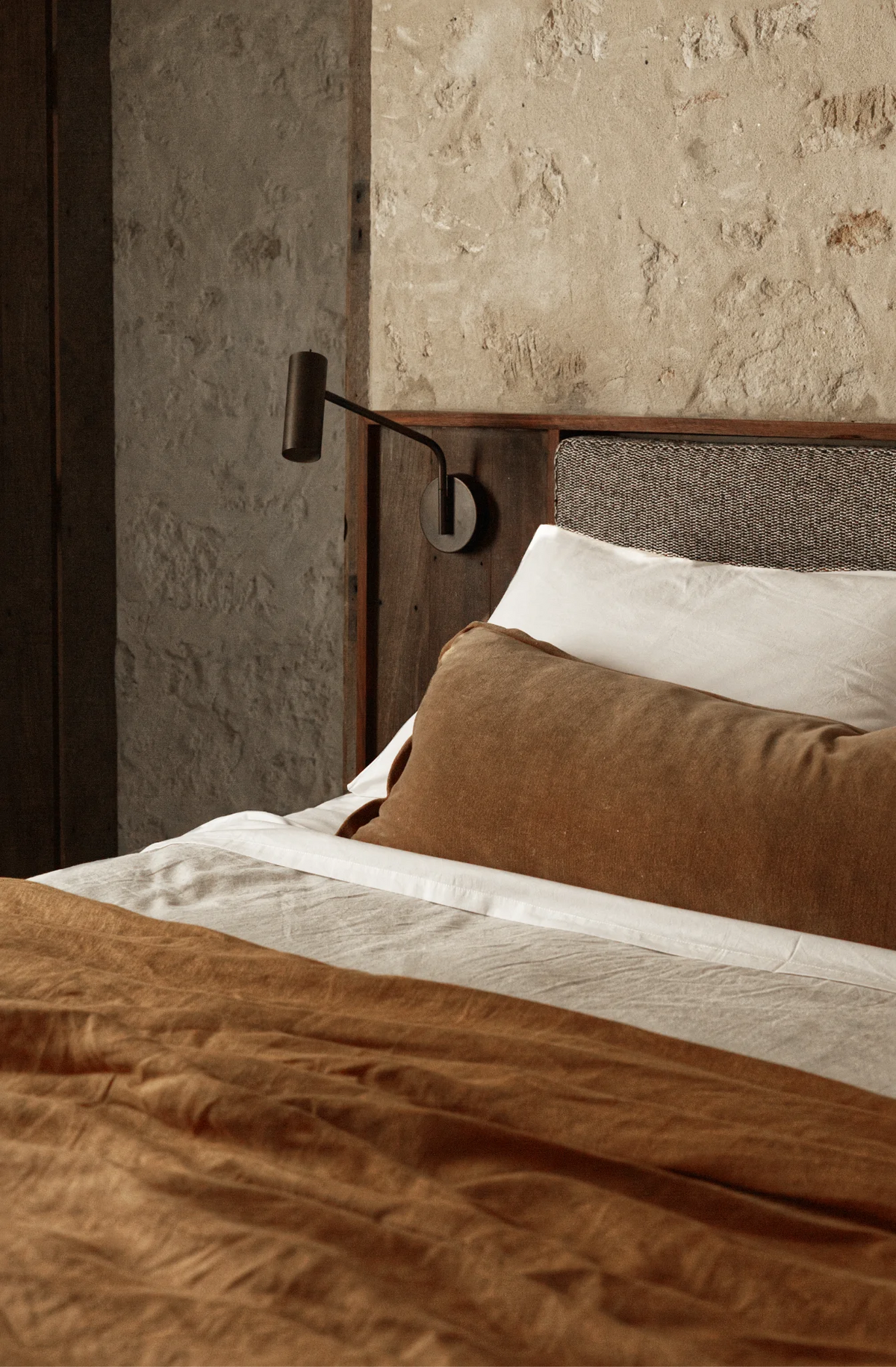 Earth-toned linen bed with side lamp
