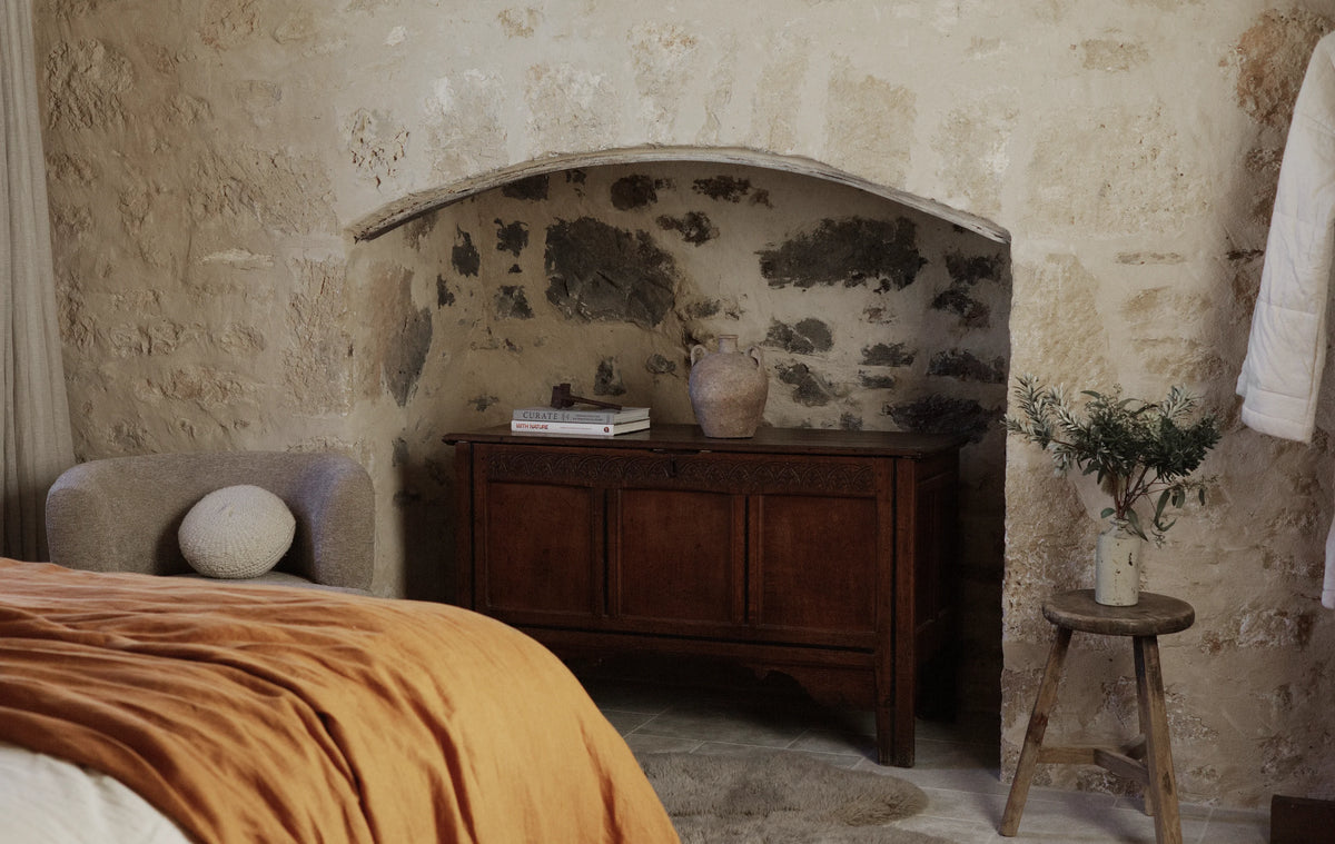 Bedroom with stone walls and wood chest